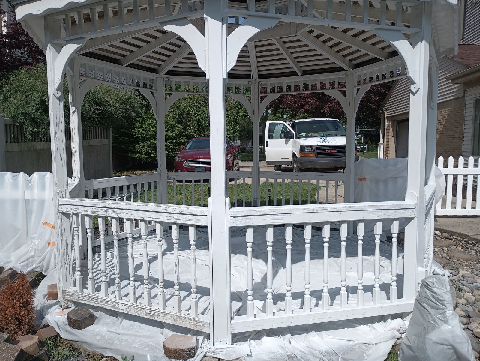 Proscope Home Painting van parked on site during a gazebo repaint, viewed through the gazebo frame