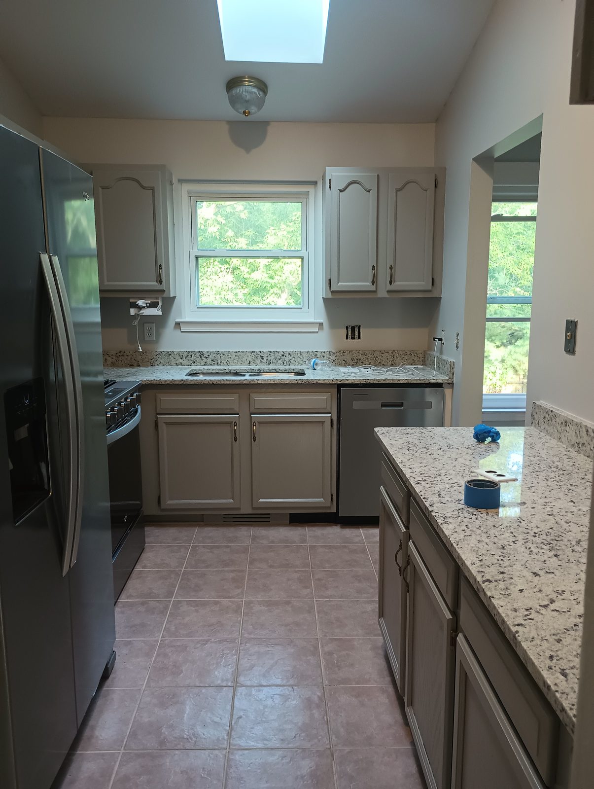 Same kitchen after, cabinets refinished in greige