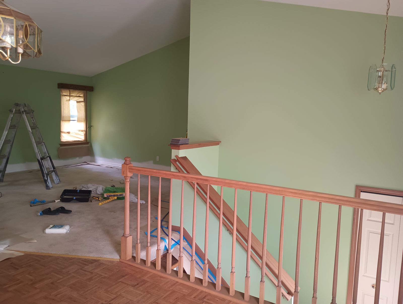 Stair landing before, green walls and orange stained railing