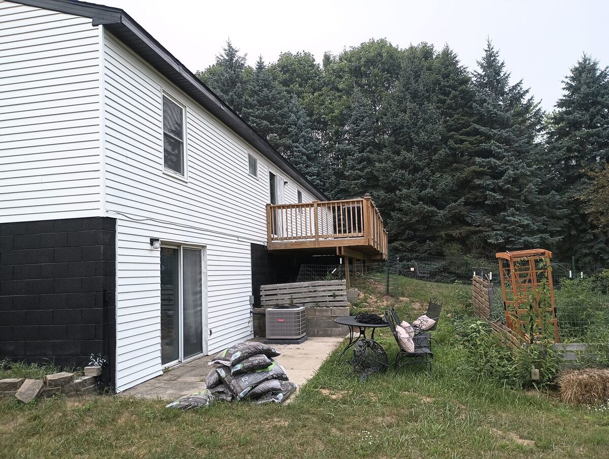 Back of house after repaint, white siding with black lower block